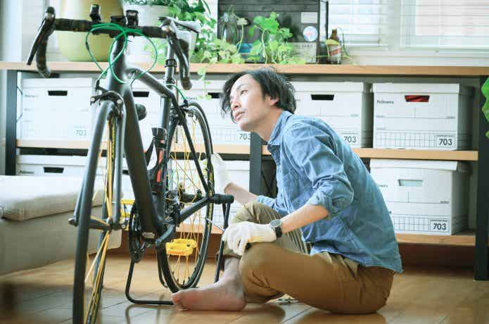 ロードバイクのメンテナンスを行う男性