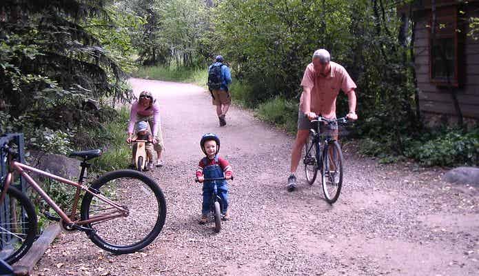 子どもに自転車の乗り方を教える家族