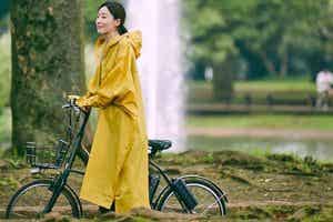 自転車と女性　レインコート　公園