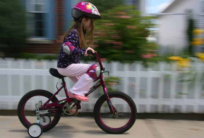 補助輪付き自転車に乗る女の子