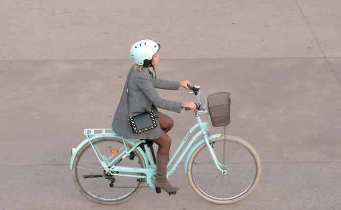 ヘルメットを被って自転車に乗る女性