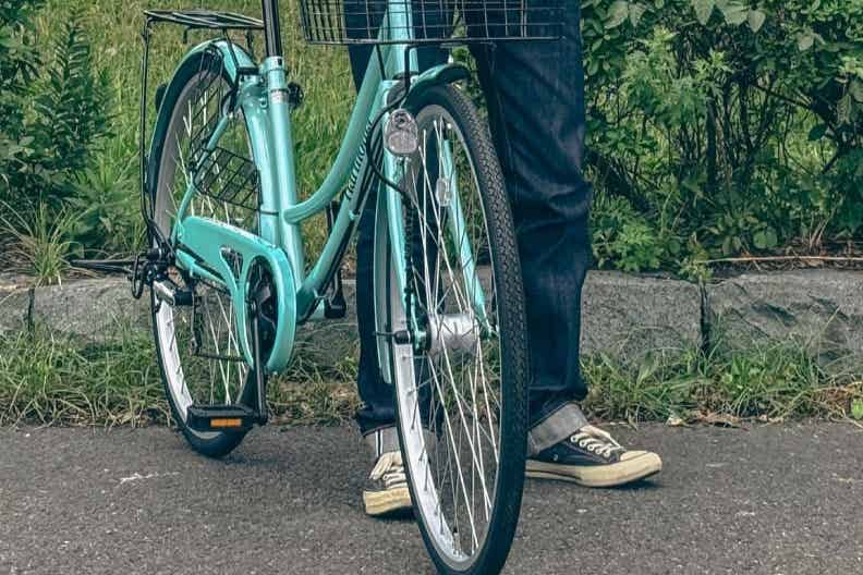 オートライト付きの自転車を押す男性