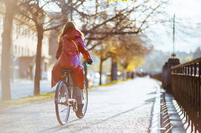 レインコートを着て自転車に乗る女性