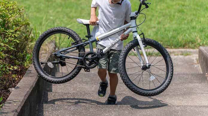 ヨツバサイクルを持ち運ぶ子ども