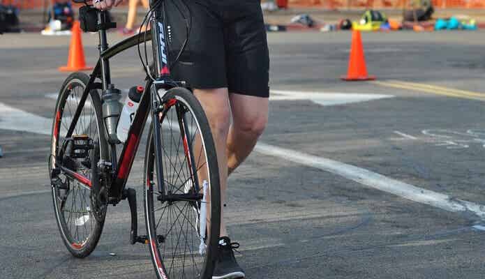 自転車を引いて歩く男性