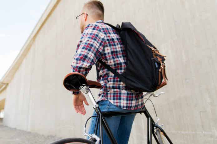 リュックを背負って自転車に乗る男性