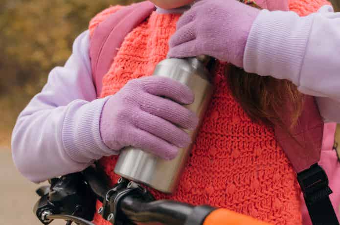 ステンレス製の水筒を握る子供