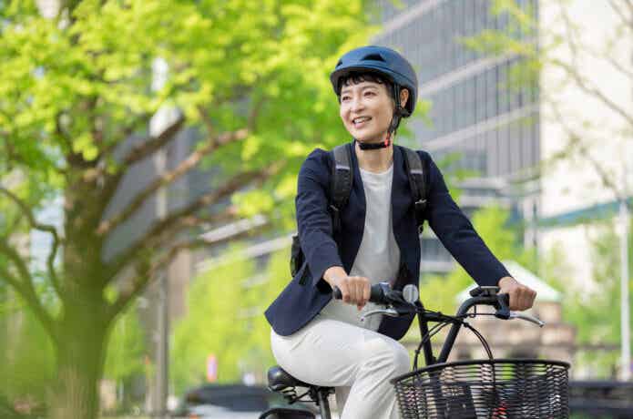 ヘルメットをかぶってクロスバイクに乗る女性