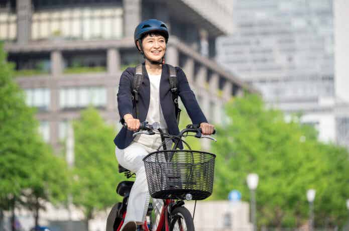 ヘルメットを被って電動自転車に乗る女性