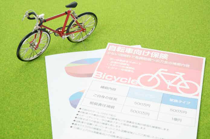 自転車保険のパンフレットと自転車のフィギュア