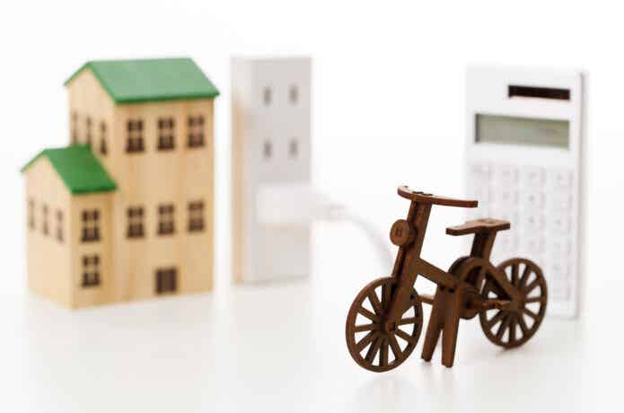 電動自転車と電卓と家の模型