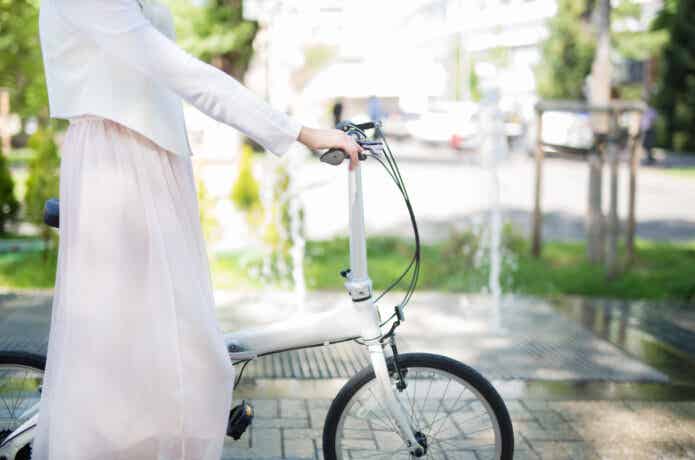 自転車を持つスカートの女性