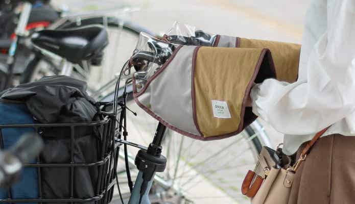 ハンドルカバー付き自転車を押す女性