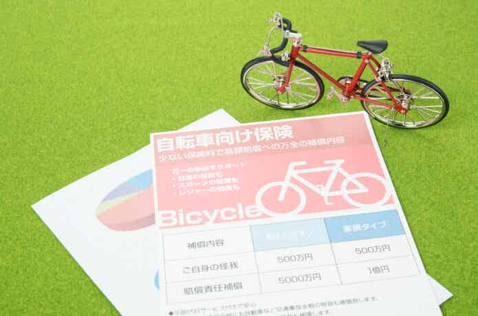 自転車保険のチラシと自転車の模型