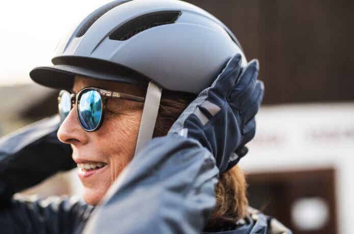 ヘルメットを手で押さえる女性