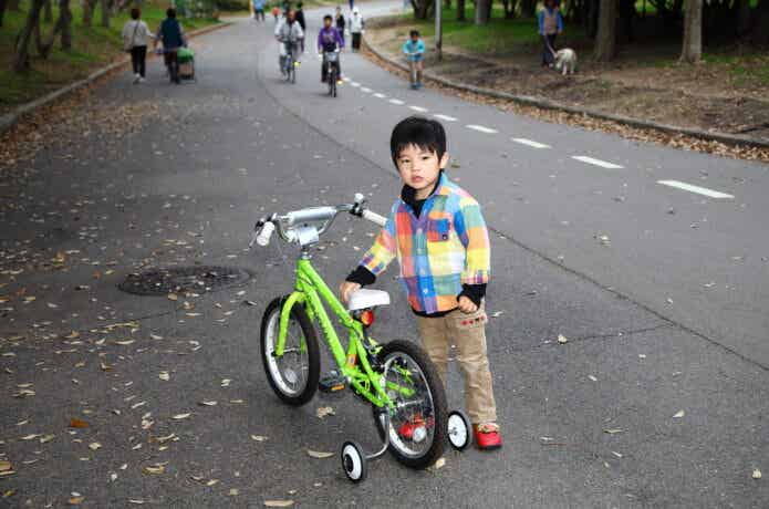 自転車の横に立つ男の子