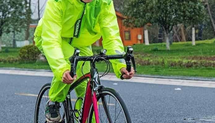 レインウエアを着て自転車に乗る男性
