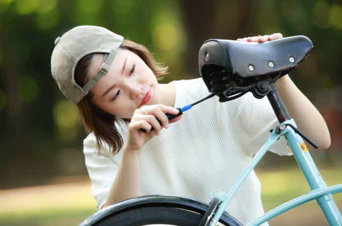 自転車のサドルを交換する女性