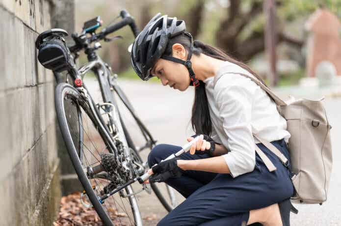 ロードバイクのタイヤに空気を入れる女性