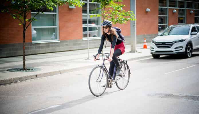 ヘルメットをかぶって自転車に乗る女性