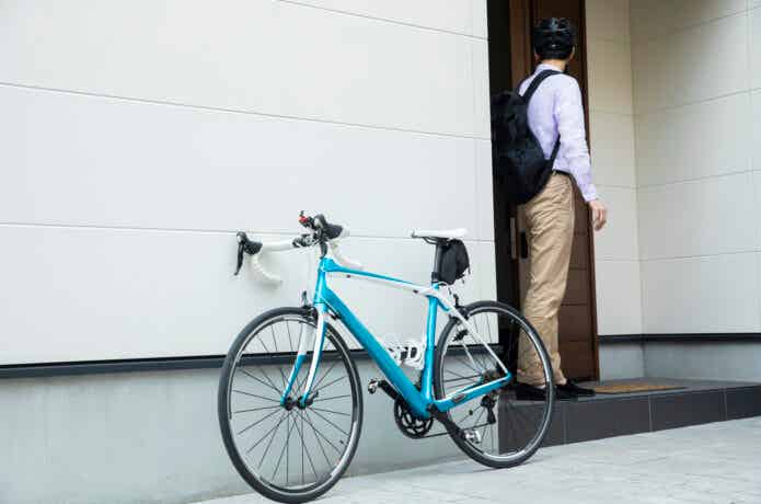 自転車通勤で家から出る男性
