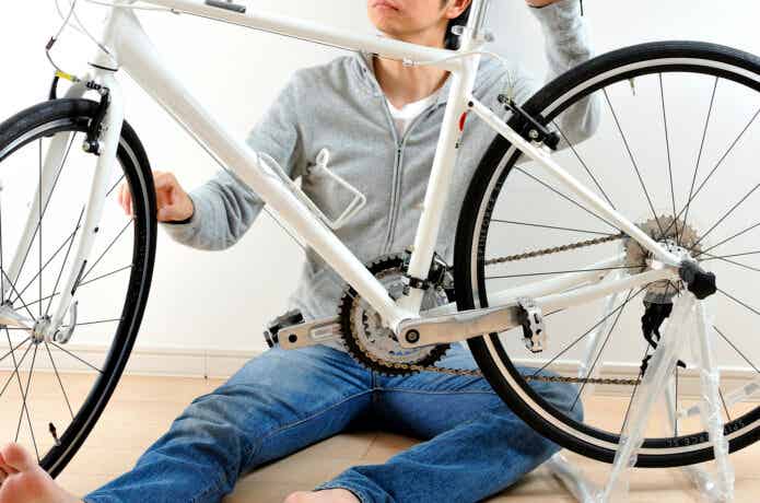自宅でクロスバイクのメンテをする男性
