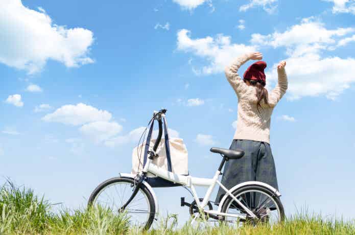自転車を止めて空を見上げる女性