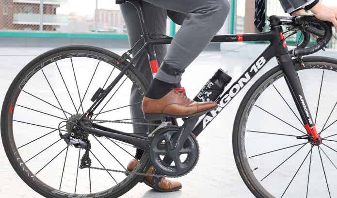 スーツでロードバイクに乗る男性