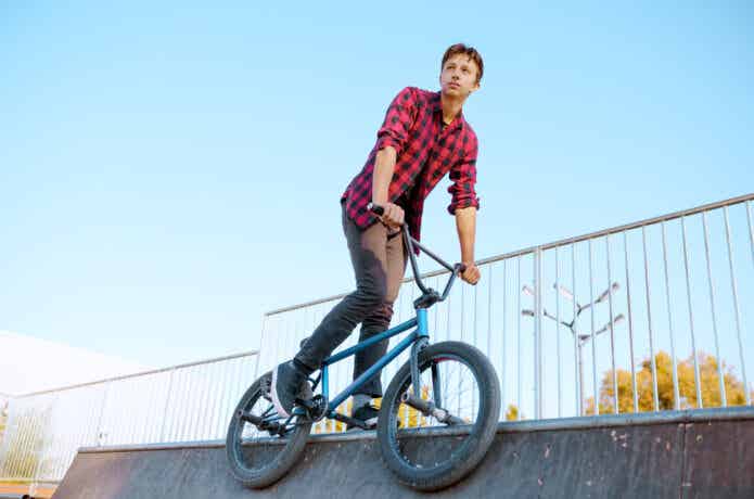 パークBMXでペグを使ってグラインドをする男性
