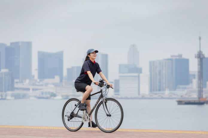クロスバイクで川沿いを走る女性