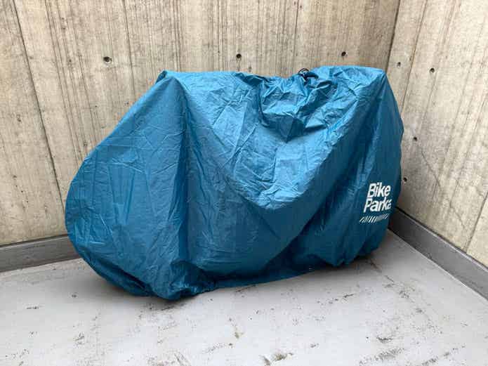 自転車カバーをかけた、ベランダに置かれたロードバイク