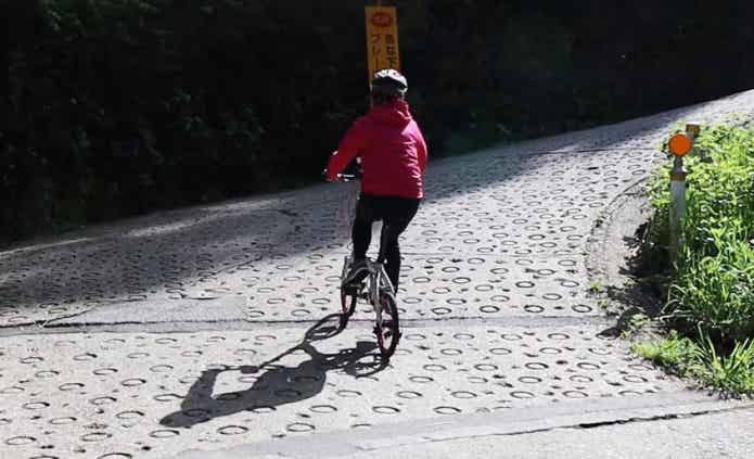 電動アシスト自転車で坂を登る女性