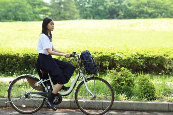 電動自転車で通学する女子学生