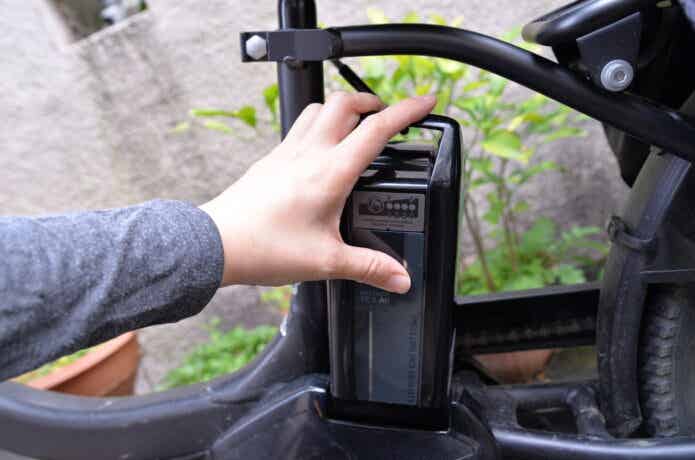 電動自転車にバッテリーを取り付けるところ