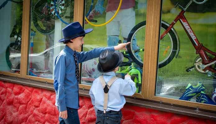 お店のウィンドウの中の自転車を見ている男の子たち