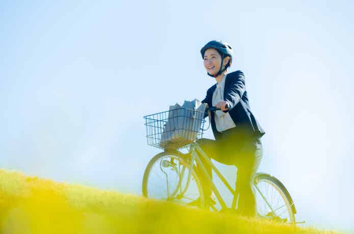 カゴ付きクロスバイクに乗る女性