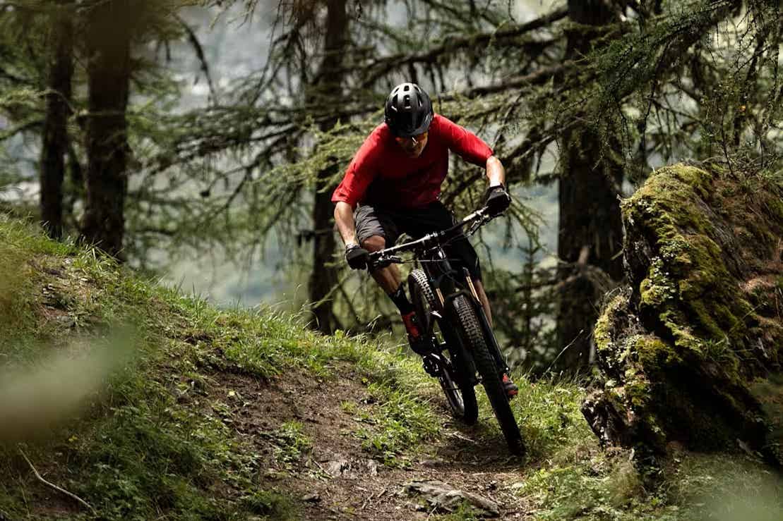 トレックのマウンテンバイクでトレイルを走る男性