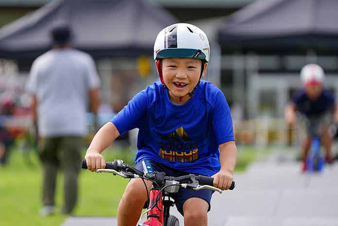 パンプトラック・フィールドを自転車で楽しむ子ども