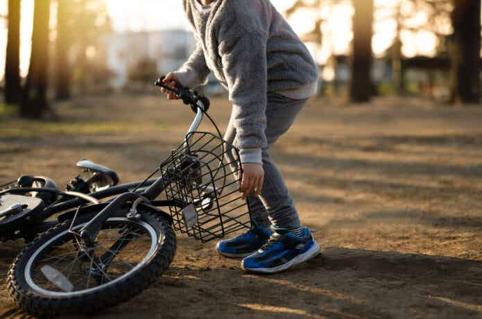 倒れた自転車を持ち上げる少年