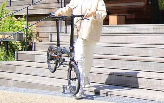 折りたたみ自転車を持ち上げる女性