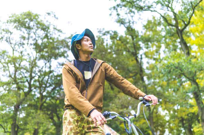 折りたたみ自転車とアウトドアウェアの若い男性