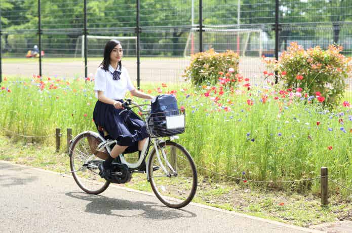 電動自転車で通学する女子学生