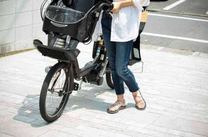 子乗せ電動自転車に乗ろうとする女性
