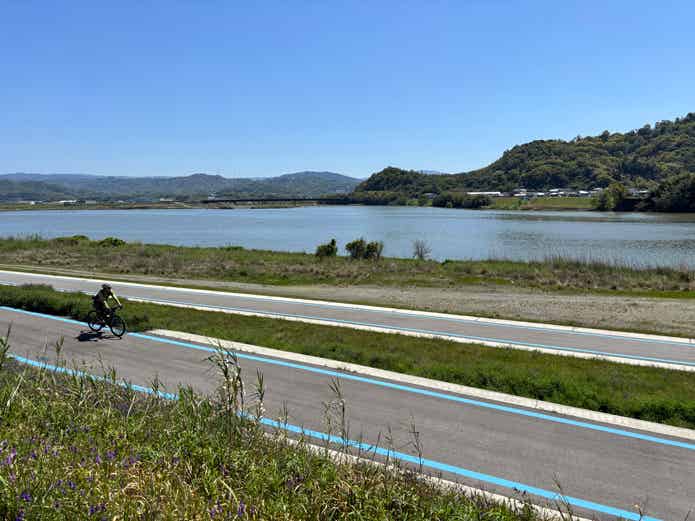 紀の川サイクリングロードをロードバイクで走る男性