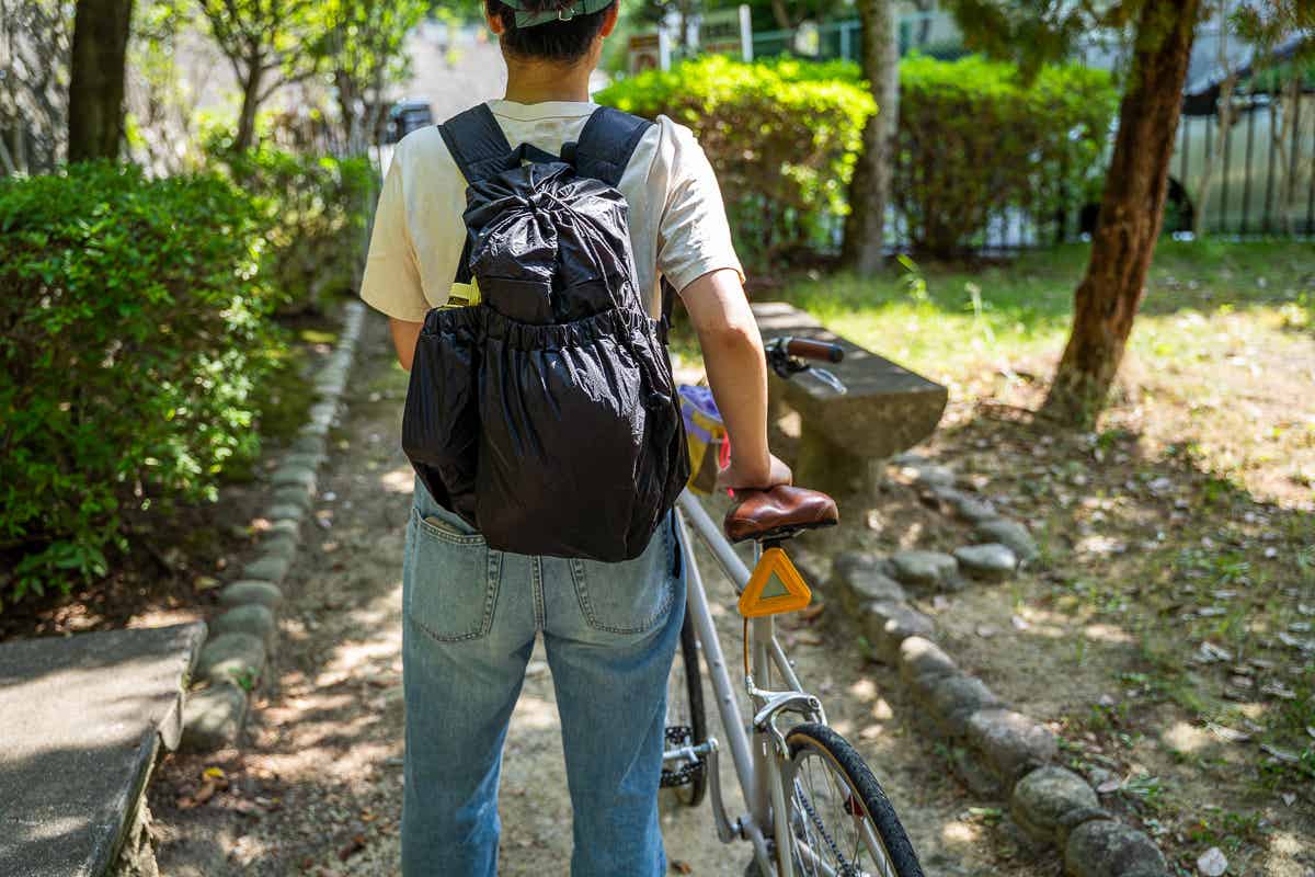FAIRWEATHER パッカブルパックを背負って、自転車をおす女性