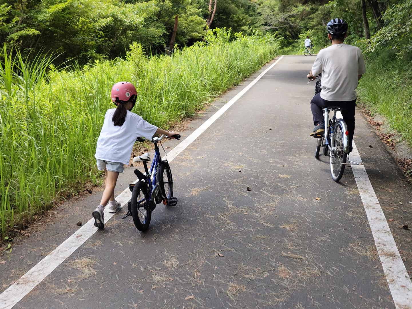 森林公園サイクリングコースで自転車を押す子供
