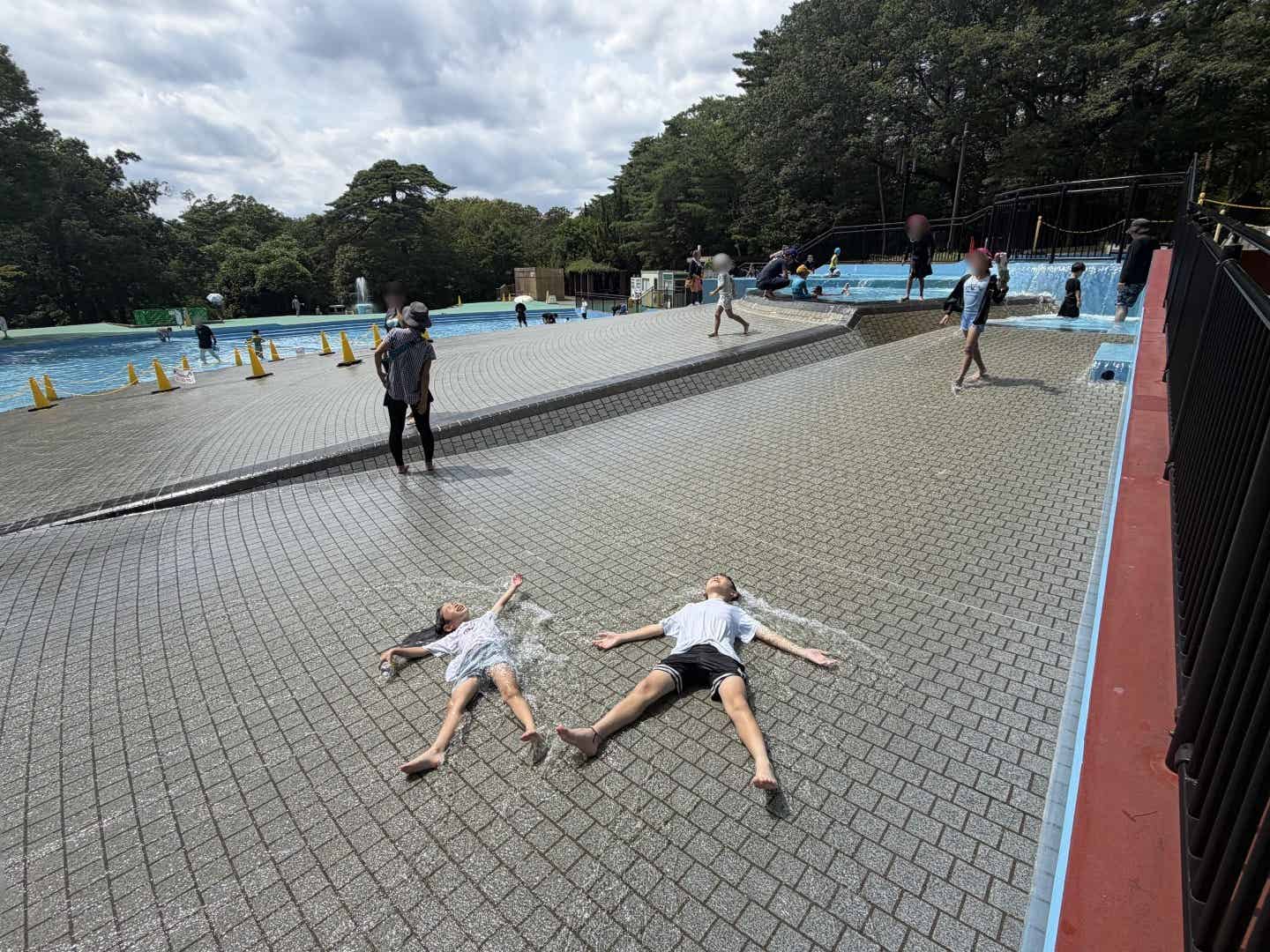 水遊び場で涼む子供