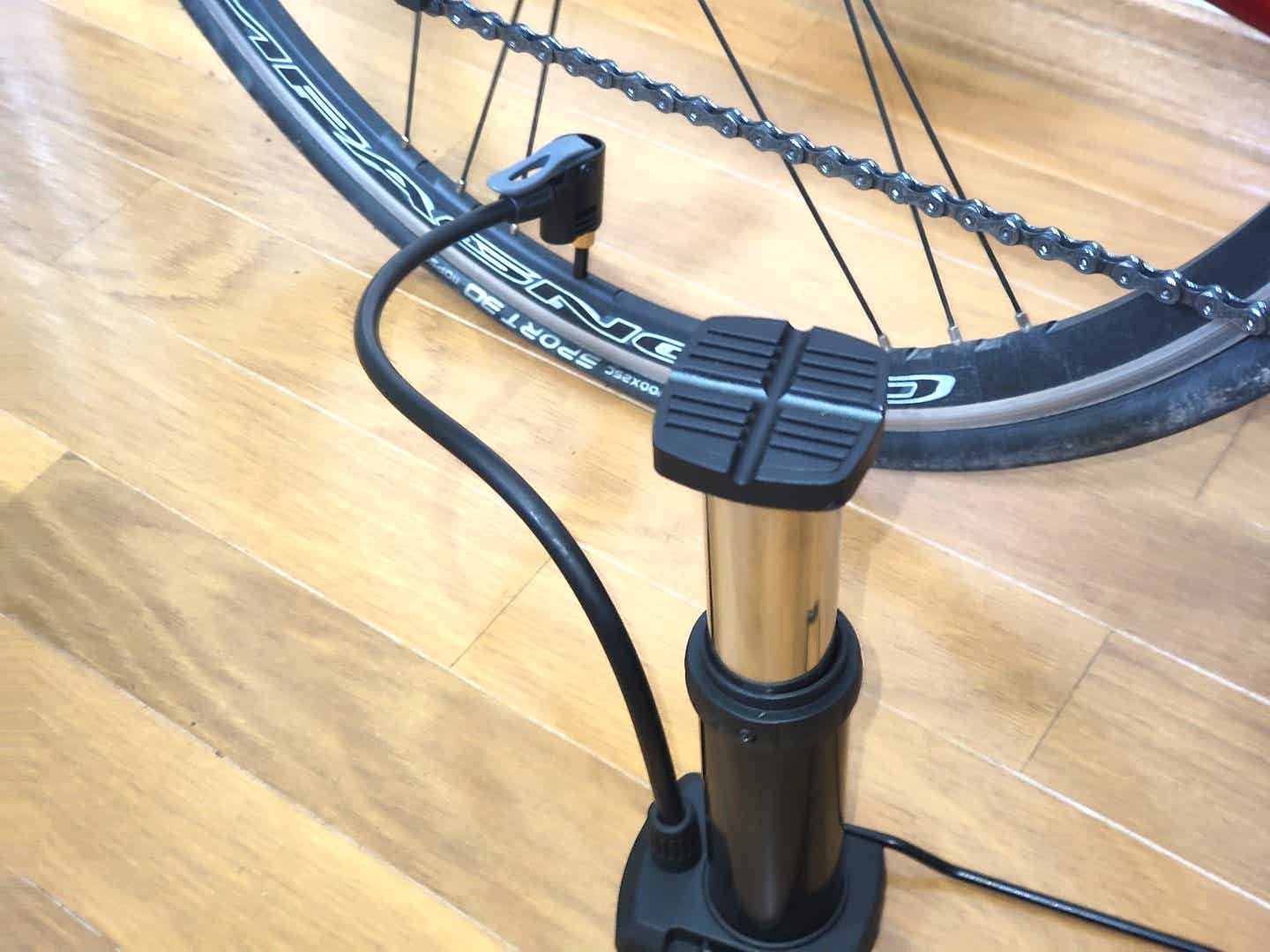 ダイソーの足ふみポンプでロードバイクに空気を入れているところ