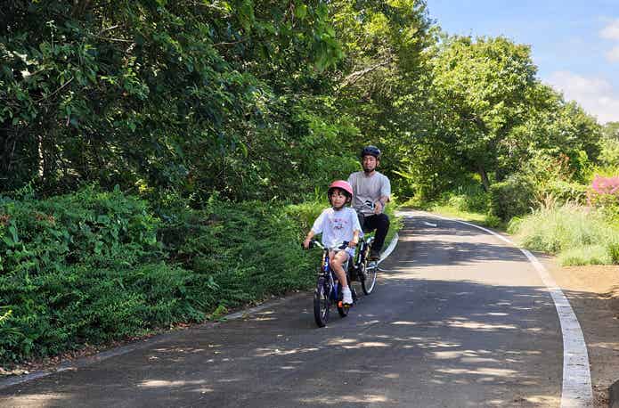 森林公園を自転車で走る親子