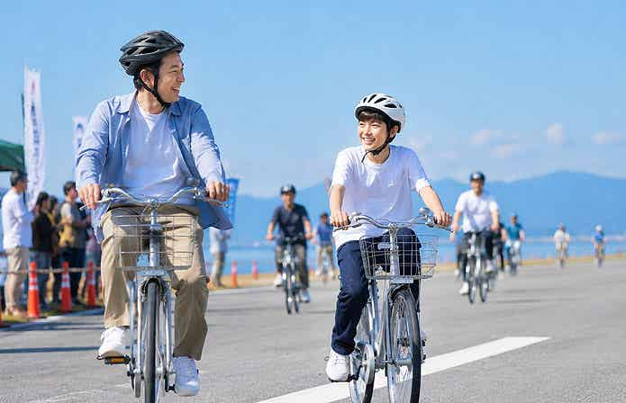 滑走路を自転車で走る親子